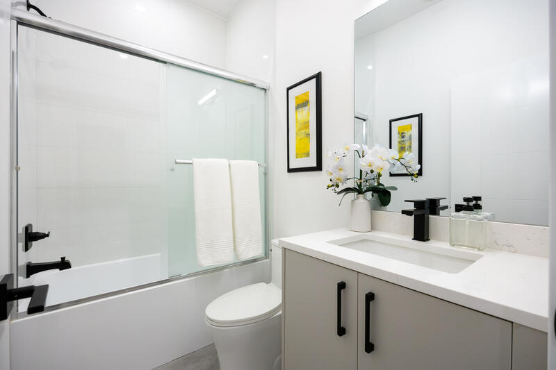 Dark scheme bathroom with grey vanity and black fixtures