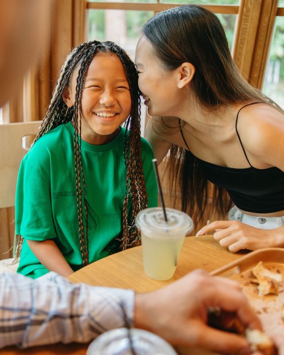 Mother and daughter laughing together at a café