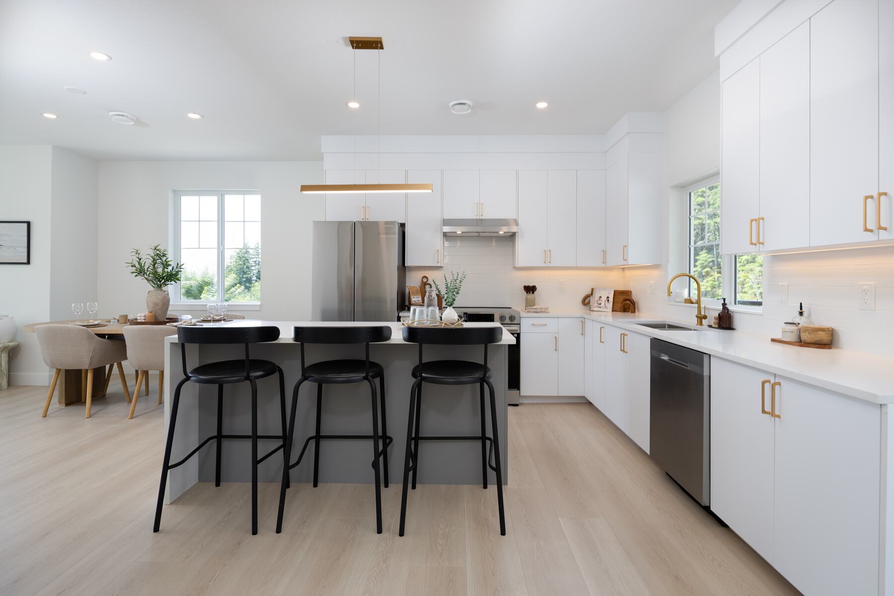 White kitchen with island seating and gold hardware